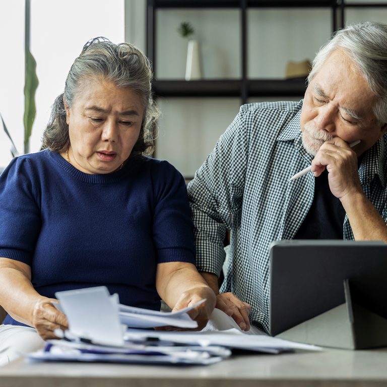 Serious stressed asian senior old couple worried about bills dis
